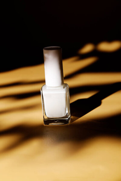 white protective nail polish in summer sand background