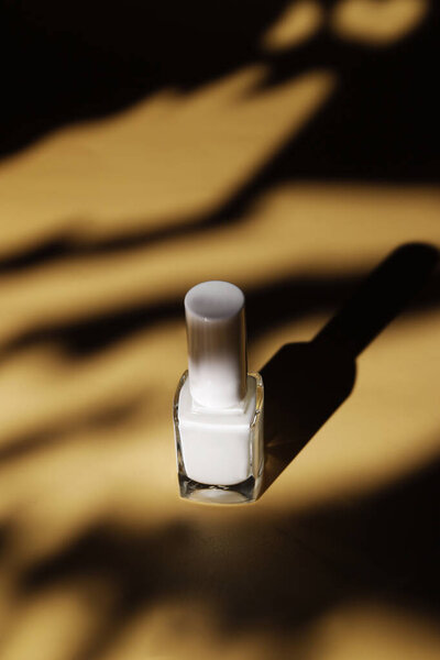 white protective nail polish in summer sand background