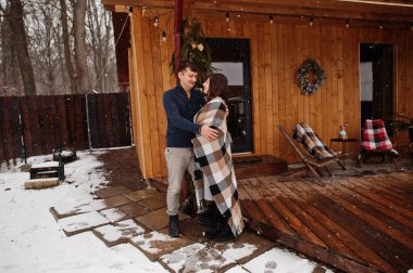 Çiftler kış günü battaniyelerini örterek ahşap eve karşı aşkla zaman geçirirler..