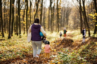 Anne ve çocukları ormanda sonbahar aktivitelerinde boş zamanlarında.. 