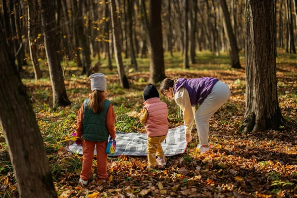 妈妈带着孩子在秋天的森林里野餐 — 图库照片