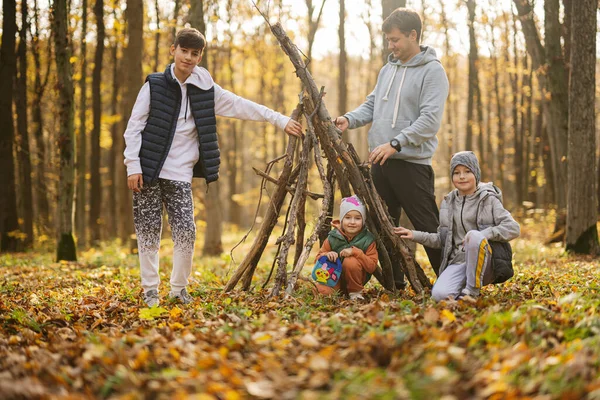 Crianças Com Pai Constrói Uma Casa Paus Floresta Outono — Fotografia de Stock