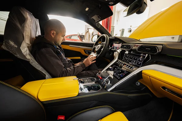 坐在黄色跑车上使用数字平板的机械手 — 图库照片