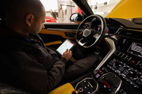 Mecânico Usando Tablet Digital Enquanto Sentado Carro Esporte Amarelo Suv — Fotografia de Stock