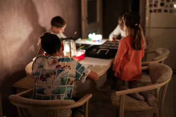 stock image Family spending time together during an energy crisis in Europe causing blackouts. Kids drawing in blackout.