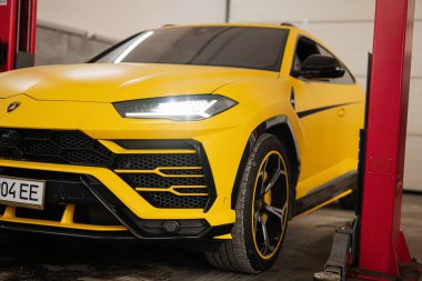Ternopil, Ukrayna... 11 Kasım 2022: Sarı Lamborghini Urus otomobil servis istasyonunda.