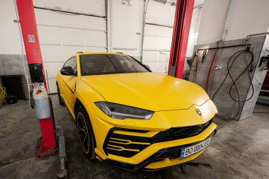 Ternopil, Ukrayna... 11 Kasım 2022: Sarı Lamborghini Urus otomobil servis istasyonunda.