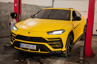 Ternopil, Ukrayna... 11 Kasım 2022: Sarı Lamborghini Urus otomobil servis istasyonunda.