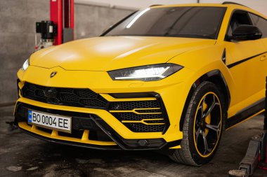 Ternopil, Ukrayna... 11 Kasım 2022: Sarı Lamborghini Urus otomobil servis istasyonunda.