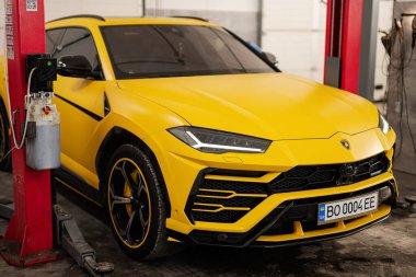 Ternopil, Ukrayna... 11 Kasım 2022: Sarı Lamborghini Urus otomobil servis istasyonunda.