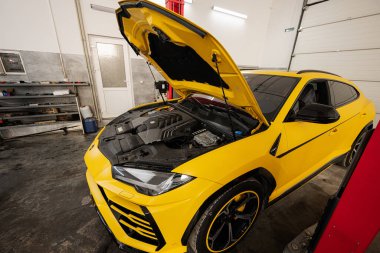 Ternopil, Ukrayna... 11 Kasım 2022: Sarı Lamborghini Urus araba servis istasyonunda kaputu açık.