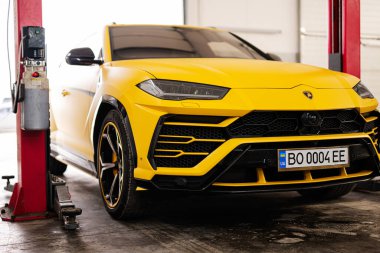 Ternopil, Ukrayna... 11 Kasım 2022: Sarı Lamborghini Urus otomobil servis istasyonunda.