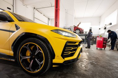 Ternopil, Ukrayna... 11 Kasım 2022: Sarı Lamborghini Urus otomobil servis istasyonunda.
