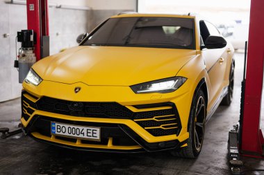 Ternopil, Ukrayna... 11 Kasım 2022: Sarı Lamborghini Urus otomobil servis istasyonunda.