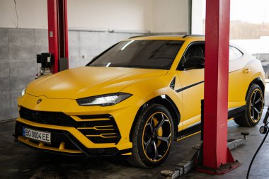 Ternopil, Ukrayna... 11 Kasım 2022: Sarı Lamborghini Urus otomobil servis istasyonunda.