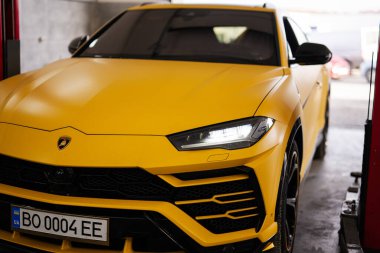 Ternopil, Ukrayna... 11 Kasım 2022: Sarı Lamborghini Urus otomobil servis istasyonunda.