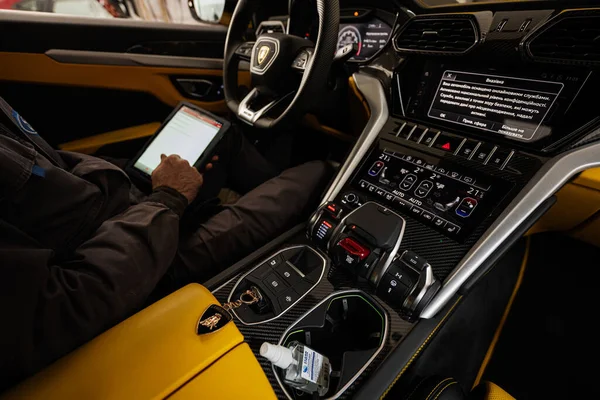 2022年11月11日 乌克兰 Ternopil 机修工带着平板电脑坐在车内 在汽车维修站测试Lamborghini Urus — 图库照片