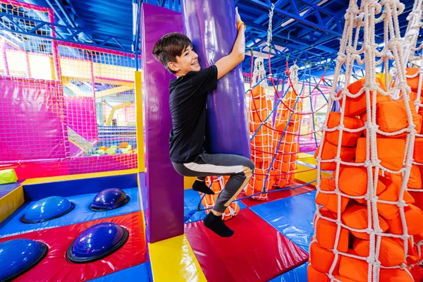 Boy playing at indoor play center playground.