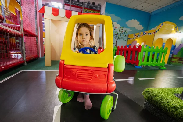 孩子们在室内游戏中心操场上玩耍 女孩们在玩具车里 — 图库照片
