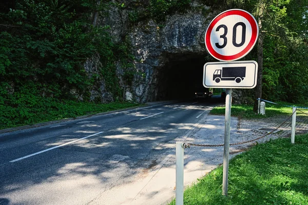 Road rocky tunnel with 30 speed limit sign in Bled, Slovenia.