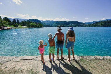 Slovenya 'nın güzel Bled Gölü manzaralı iskelede dört çocuk dikiliyor.