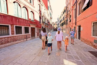 Aile turistleri Ramo De La Piscina caddesinde yürüyor, Venedik, İtalya.