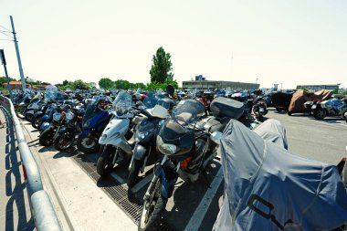 Venedik, İtalya - 4 Temmuz 2022: Venedik, İtalya 'da güneşli bir yaz gününde sokak otoparkında scooterlar, motosikletler ve motosikletler.