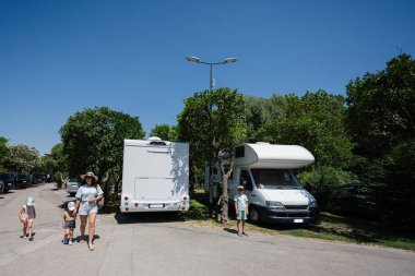 Park 'ta karavan parkına yakın bir aile, karavan gezisi, tatilde karavan arabası..