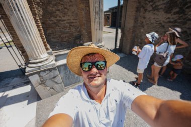 Şapkalı ve güneş gözlüklü bir turist Pompeii antik şehri İtalya 'da selfie çekiyor..