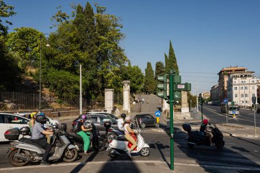 Roma, İtalya - 27 Temmuz 2022: Scooter sürücüleri Roma, İtalya 'da trafik ışıklarında duruyorlar.