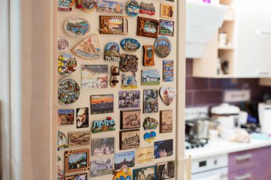 Ternopil, Ukraine - January 11, 2023: Refrigerator filled by lots magnets souvenirs from travel.