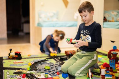Çocuk eğlencesi, yaratıcı oyun. Erkek ve kız kardeş evde oynuyor..