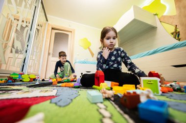 Çocuk eğlencesi, yaratıcı oyun. Çocuklar evde oyuncak trenle oynuyorlar..