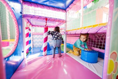 Mutlu kız kardeşler oyun bahçesinde oynuyorlar..