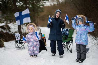 Three finnish children with Finland flags on a nice winter day. Nordic Scandinavian people. 
