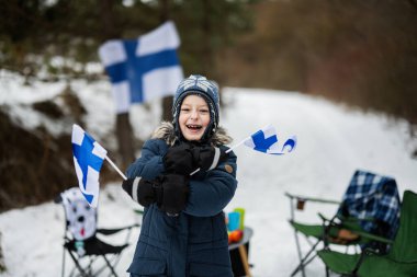 Finnish boy with Finland flags on a nice winter day. Nordic Scandinavian people.  clipart