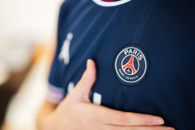 Ternopil, Ukraine - February, 2023: Boy put hand on heart, wear of PSG Paris Saint Germain football club uniform.