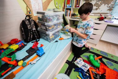 Ternopil, Ukraine - February, 2023: Boy unboxing Hot Wheels City Ultimate Garage, play in children room.