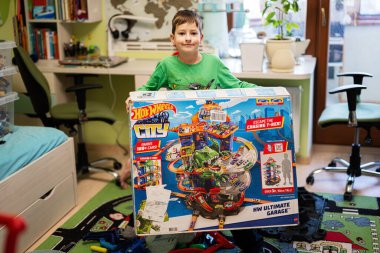 Ternopil, Ukraine - February, 2023: Boy unboxing Hot Wheels City Ultimate Garage, play in children room.
