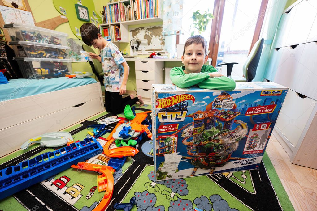 Ternopil, Ukraine - February, 2023: Kids unboxing Hot Wheels City Ultimate Garage, play in children room.