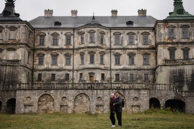 Couple tourists against Pidhirtsi Castle, Lviv region, Ukraine. 