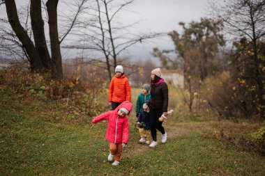 Mother with her four kids in autumn forest.