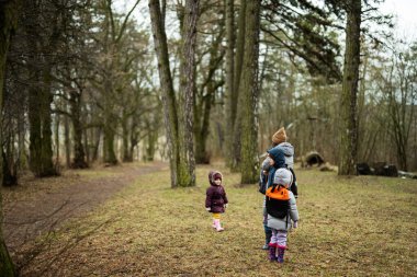 Mom and children in the forest after rain together.