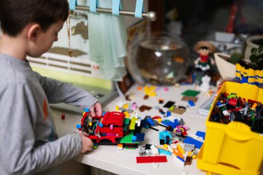 Ternopil, Ukraine - February, 2023: Boy kid constructing toy use Lego Classic at home.