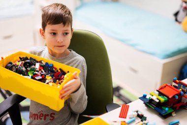 Ternopil, Ukraine - February, 2023: Boy kid constructing toy use Lego Classic at home.