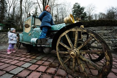 Kids at green retro carriage handmade car.