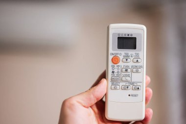 Air conditioner with man operating remote controller.