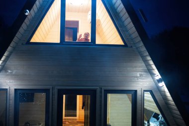 Geceleri üçgen kır evindeki küçük kızın penceresinden bak..