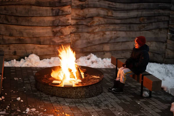 Αγόρι Κάθεται Δίπλα Στη Φωτιά Χειμώνα Βράδυ — Φωτογραφία Αρχείου