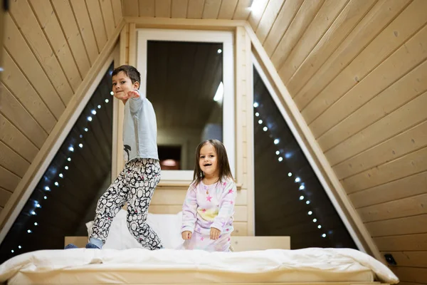 穿着柔软暖和的睡衣在木屋里玩耍的孩子们 童年的概念 休闲活动 哥哥和姐姐玩得开心 一起玩 — 图库照片